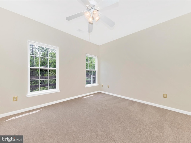 carpeted spare room with baseboards and ceiling fan