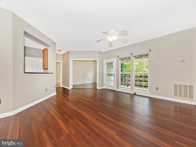 spare room featuring a ceiling fan, wood finished floors, and baseboards