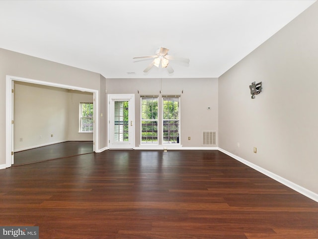 unfurnished room with ceiling fan, healthy amount of natural light, wood finished floors, and baseboards
