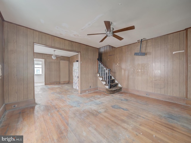820 Tuckerman St NW, Washington, DC 20011 - unfurnished room with a ceiling fan, stairs, wooden walls, and wood-type flooring