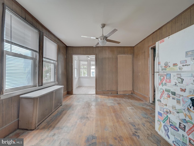 820 Tuckerman St NW, Washington, DC 20011 - unfurnished room with radiator, ceiling fan, wood walls, and light wood finished floors