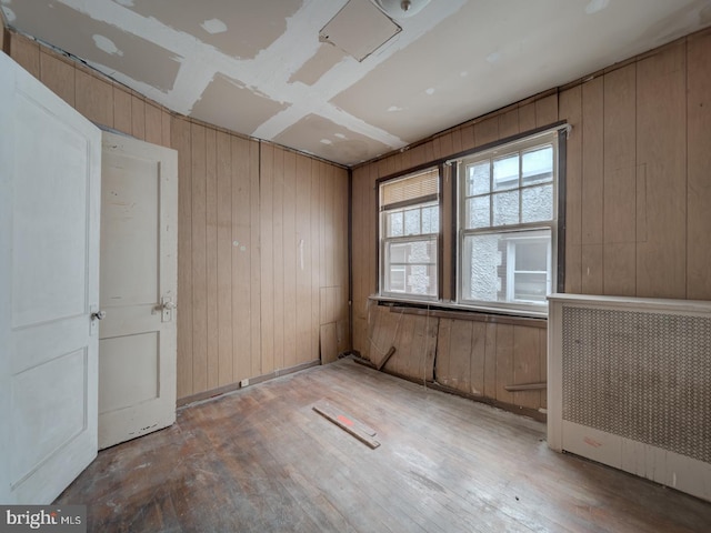 820 Tuckerman St NW, Washington, DC 20011 - unfurnished room with wooden walls, hardwood / wood-style floors, and radiator