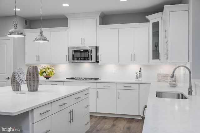 kitchen featuring appliances with stainless steel finishes, a sink, recessed lighting, white cabinetry, and pendant lighting