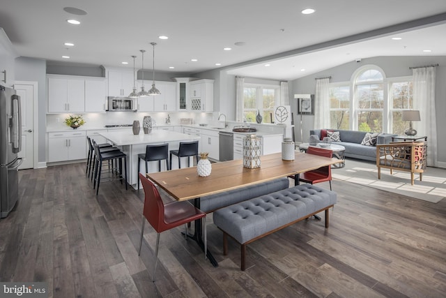 dining room featuring vaulted ceiling, dark wood finished floors, and recessed lighting