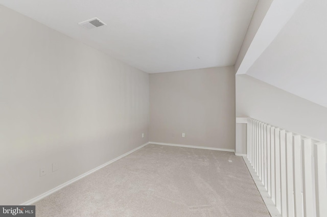 additional living space with light colored carpet and baseboards