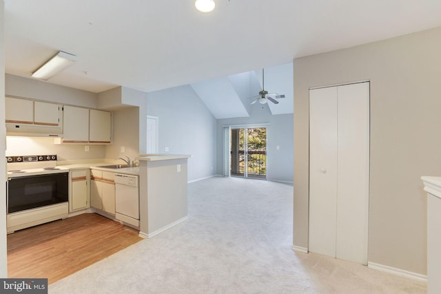 kitchen with white appliances, under cabinet range hood, a peninsula, light colored carpet, and vaulted ceiling