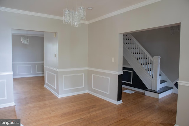 5519 Minnoka Ave, Baltimore, MD 21215 - unfurnished dining area featuring a chandelier, stairs, light wood-style flooring, crown molding, and a decorative wall