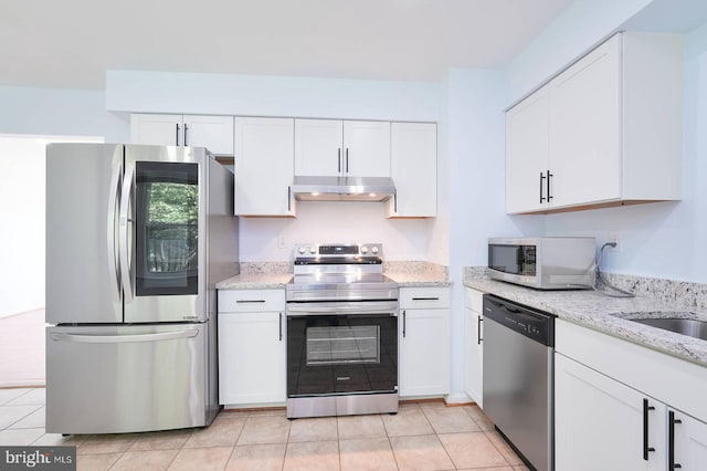 2012 All Hallows Ct, Waldorf, MD 20602 - kitchen featuring appliances with stainless steel finishes, under cabinet range hood, white cabinets, light tile patterned flooring, and light stone counters