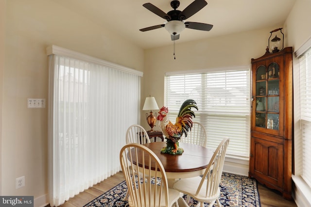 dining room featuring wood finished floors, ceiling fan, and baseboards