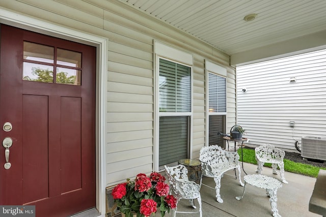 doorway to property featuring a porch and cooling unit