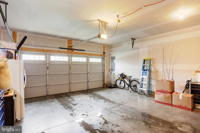 garage featuring a garage door opener and freestanding refrigerator