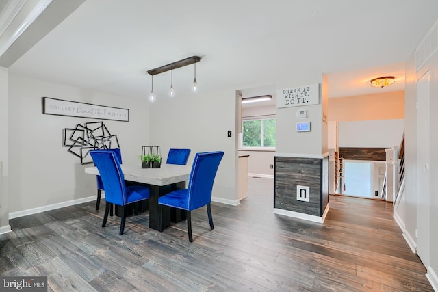 dining area featuring dark wood-style flooring and baseboards