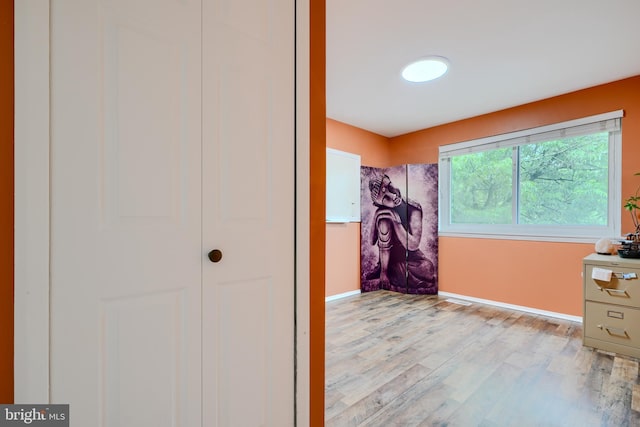 bathroom with wood finished floors and baseboards