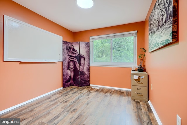 unfurnished room featuring wood finished floors and baseboards