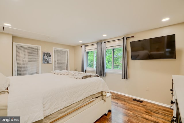 bedroom featuring wood finished floors, baseboards, recessed lighting, and attic access
