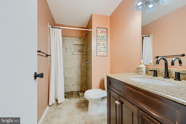 bathroom featuring a tile shower, toilet, and vanity
