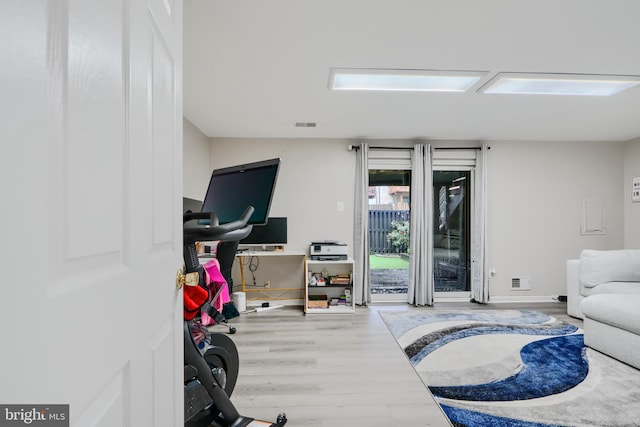 bedroom featuring access to outside, wood finished floors, and baseboards