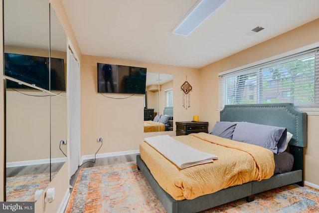 bedroom featuring wood finished floors and baseboards