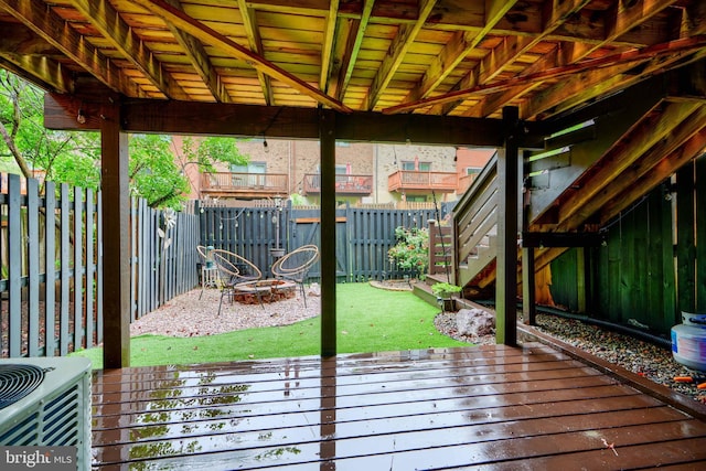 wooden terrace featuring a fenced backyard, central AC unit, and stairs