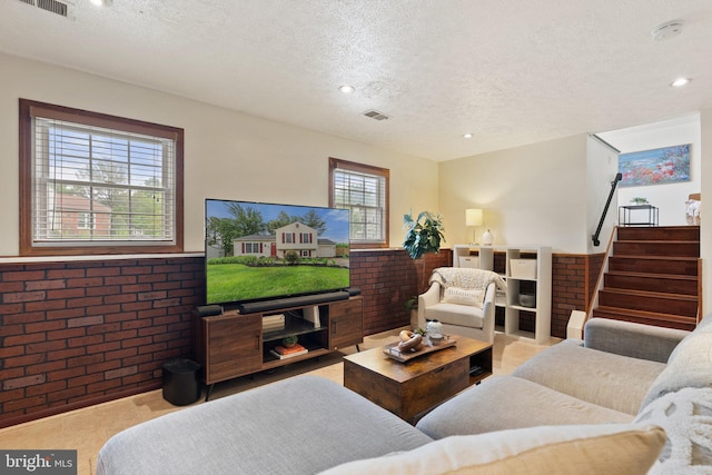 12821 Flagship Ave, Herndon, VA 20170 - living room featuring stairs, a textured ceiling, wainscoting, recessed lighting, and brick wall