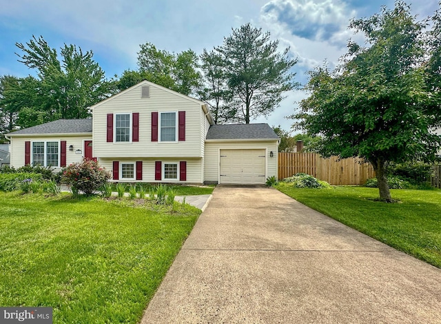 tri-level home featuring a garage, driveway, and a shingled roof