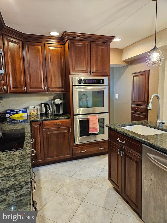 615 Bryn Mawr Ave, Penn Valley, PA 19072 - kitchen with a sink, appliances with stainless steel finishes, light tile patterned floors, dark stone countertops, and hanging light fixtures