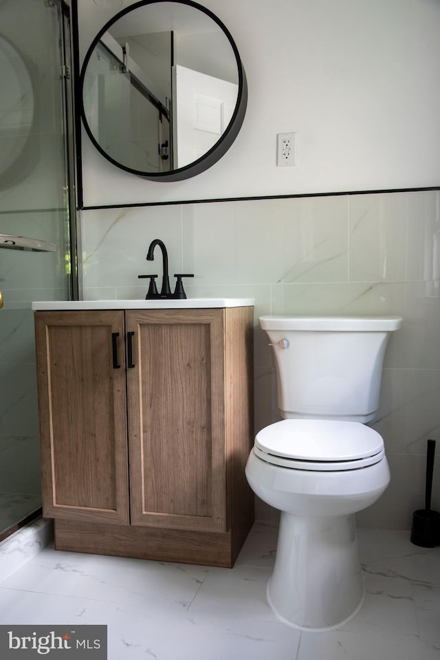 615 Bryn Mawr Ave, Penn Valley, PA 19072 - bathroom featuring marble finish flooring, toilet, vanity, and tile walls