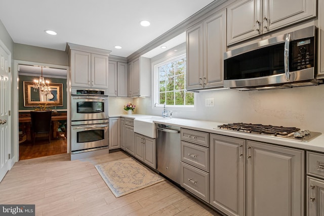 8412 Riverside Rd, Alexandria, VA 22308 - kitchen with gray cabinets, appliances with stainless steel finishes, a chandelier, light countertops, and recessed lighting