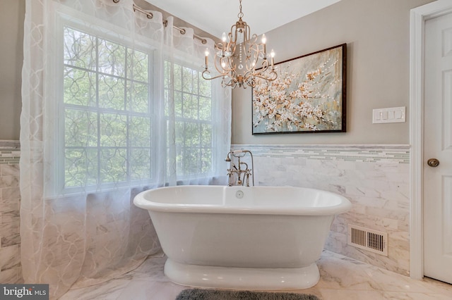 8412 Riverside Rd, Alexandria, VA 22308 - full bathroom with tile walls, marble tiled flooring, a freestanding tub, a chandelier, and a wainscoted wall