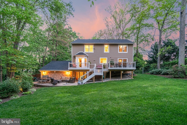 8412 Riverside Rd, Alexandria, VA 22308 - back of house at dusk featuring a wooden deck, an outdoor living space, stairway, a yard, and a patio area