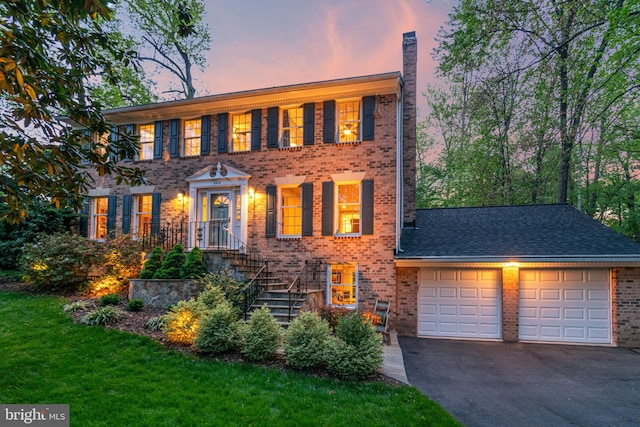 8412 Riverside Rd, Alexandria, VA 22308 - colonial house with brick siding, a chimney, a garage, and asphalt driveway