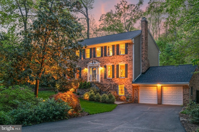8412 Riverside Rd, Alexandria, VA 22308 - colonial home with brick siding, a chimney, an attached garage, driveway, and a shingled roof