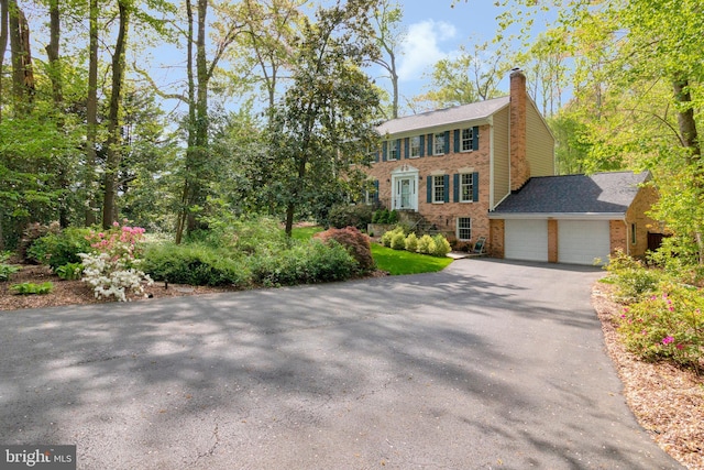 8412 Riverside Rd, Alexandria, VA 22308 - colonial inspired home with brick siding, driveway, a chimney, and a garage