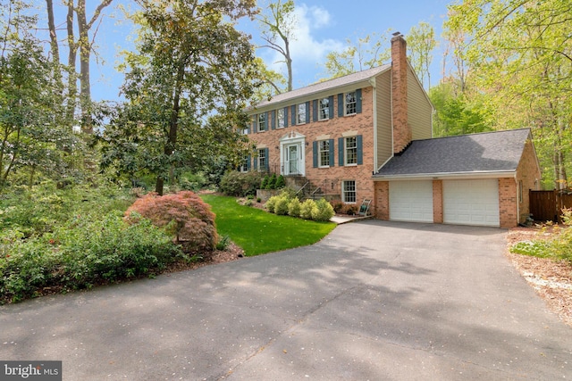 8412 Riverside Rd, Alexandria, VA 22308 - colonial house with a garage, a chimney, brick siding, driveway, and a front lawn