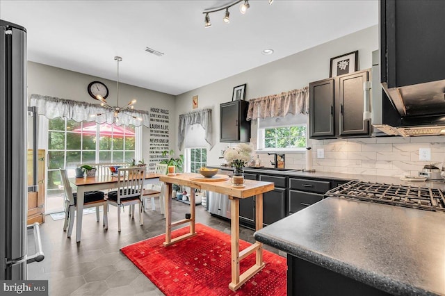 511 Abrams Ct, Bear, DE 19701 - kitchen featuring dark countertops, a sink, a chandelier, decorative backsplash, and cooktop