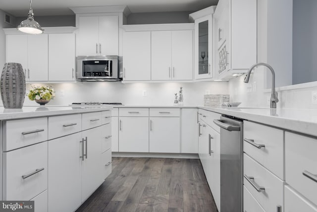 kitchen featuring stainless steel appliances, light countertops, dark wood finished floors, white cabinetry, and glass insert cabinets