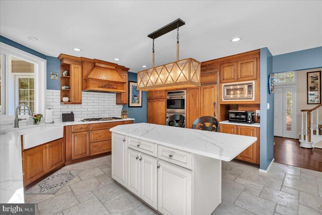 kitchen with open shelves, a sink, stone tile flooring, tasteful backsplash, and stainless steel appliances