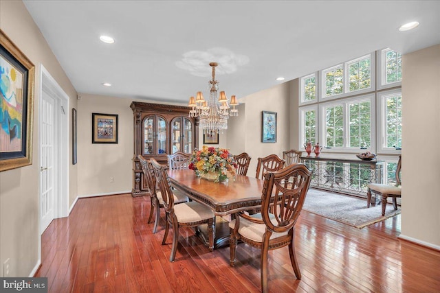 dining area with a chandelier, wood-type flooring, baseboards, and recessed lighting