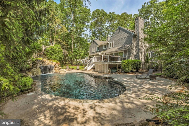 swimming pool featuring stairway, fence, a patio area, and a deck