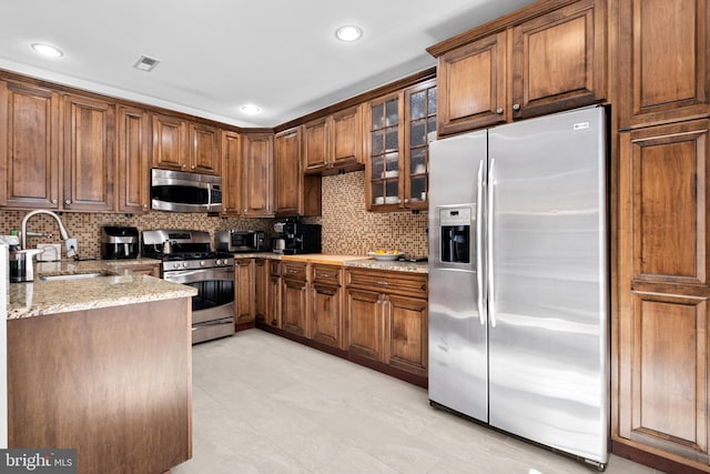 110 Commodore Ct, Philadelphia, PA 19146 - kitchen featuring stainless steel appliances, a sink, tasteful backsplash, light stone counters, and recessed lighting