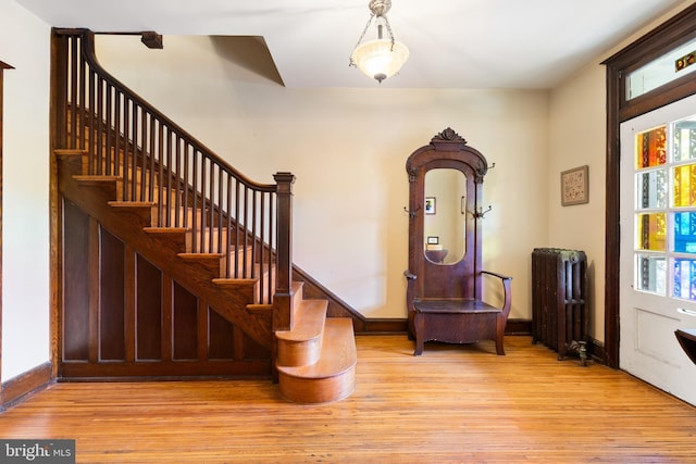 3650 Park Pl NW, Washington, DC 20010 - entrance foyer with radiator, light wood finished floors, and stairway