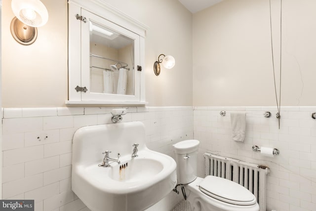 3650 Park Pl NW, Washington, DC 20010 - bathroom featuring radiator heating unit, tile walls, wainscoting, and a shower with shower curtain