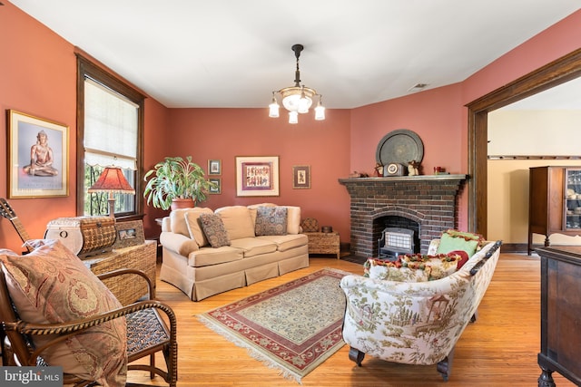 3650 Park Pl NW, Washington, DC 20010 - living room featuring wood finished floors, a brick fireplace, and a chandelier