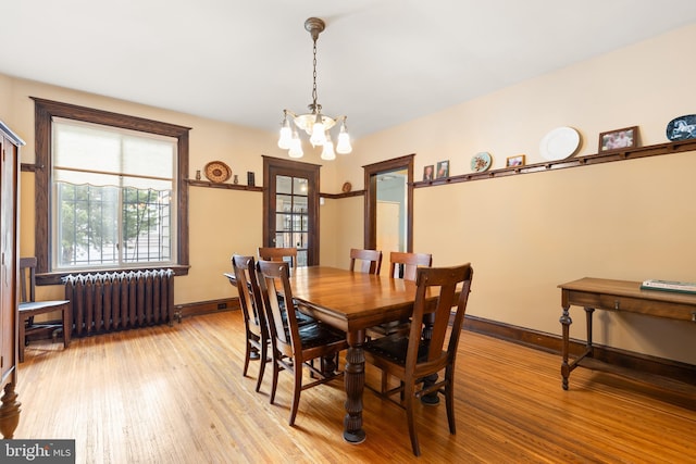 3650 Park Pl NW, Washington, DC 20010 - dining room featuring radiator heating unit, a chandelier, and light wood-style floors