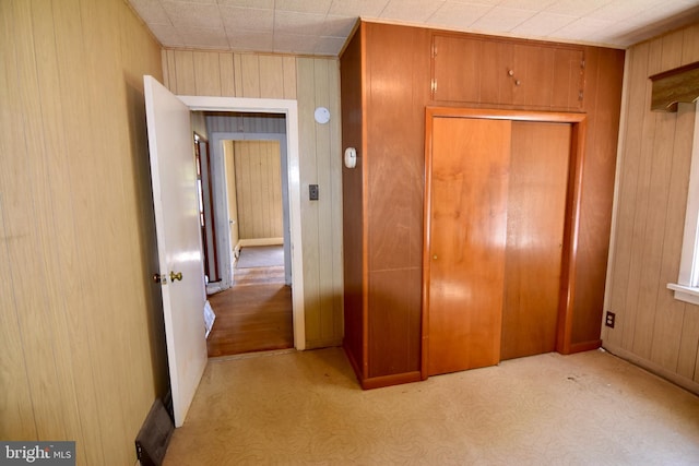 unfurnished bedroom with wood walls, a closet, and baseboards