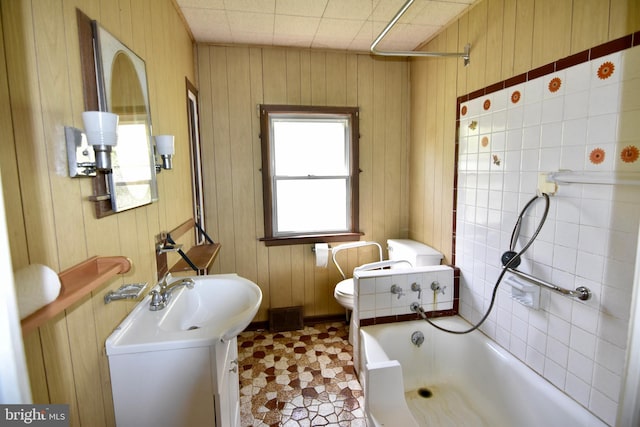 full bath with vanity, toilet, and wood walls