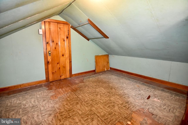 additional living space featuring lofted ceiling and baseboards