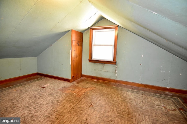 additional living space with vaulted ceiling and baseboards