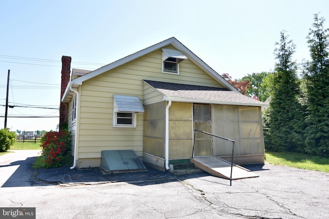 back of property with a shingled roof