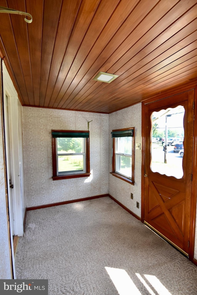 entrance foyer with wooden ceiling, carpet floors, and baseboards